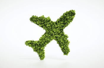 Green airplane silhouette made of leaves, symbolizing sustainable aviation fuel and the decarbonization of air transport.