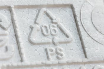 Recycled polystyrene materials moving through recovery and manufacturing processes, illustrating how flame-retardant PS can be transformed into new products as part of a circular value chain.